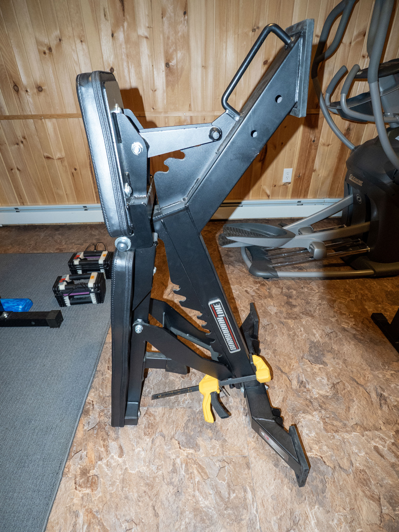 Trigger clamp used to store heavy duty weight bench vertically. Picture one.